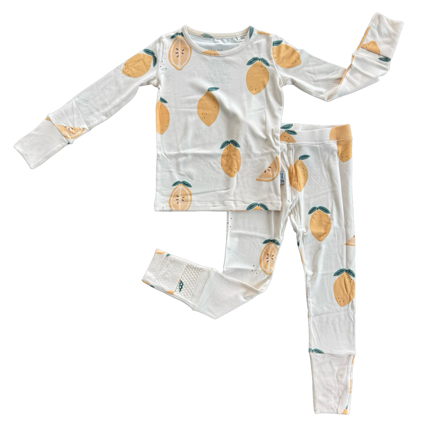 A two-piece children's pajama set featuring a long-sleeve top and matching pants, both in white with a repeating lemon print, laid flat on a white background.