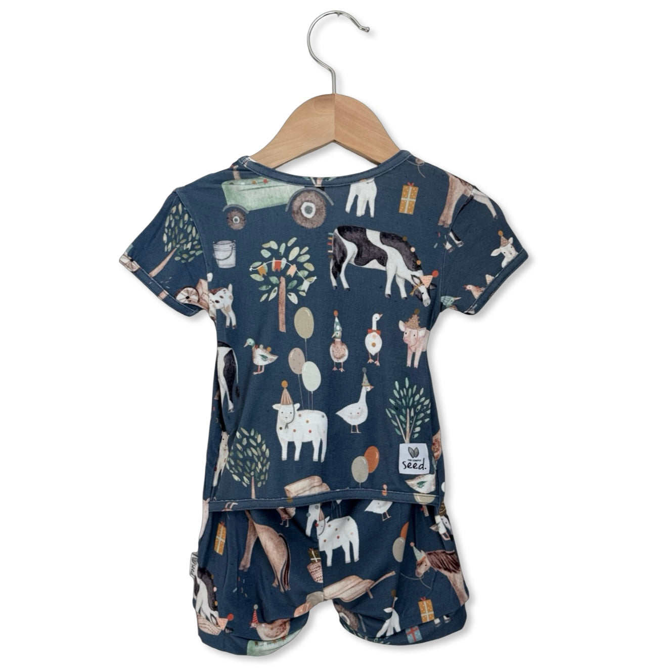 Children's pajama set with animal pattern on a hanger against a white background