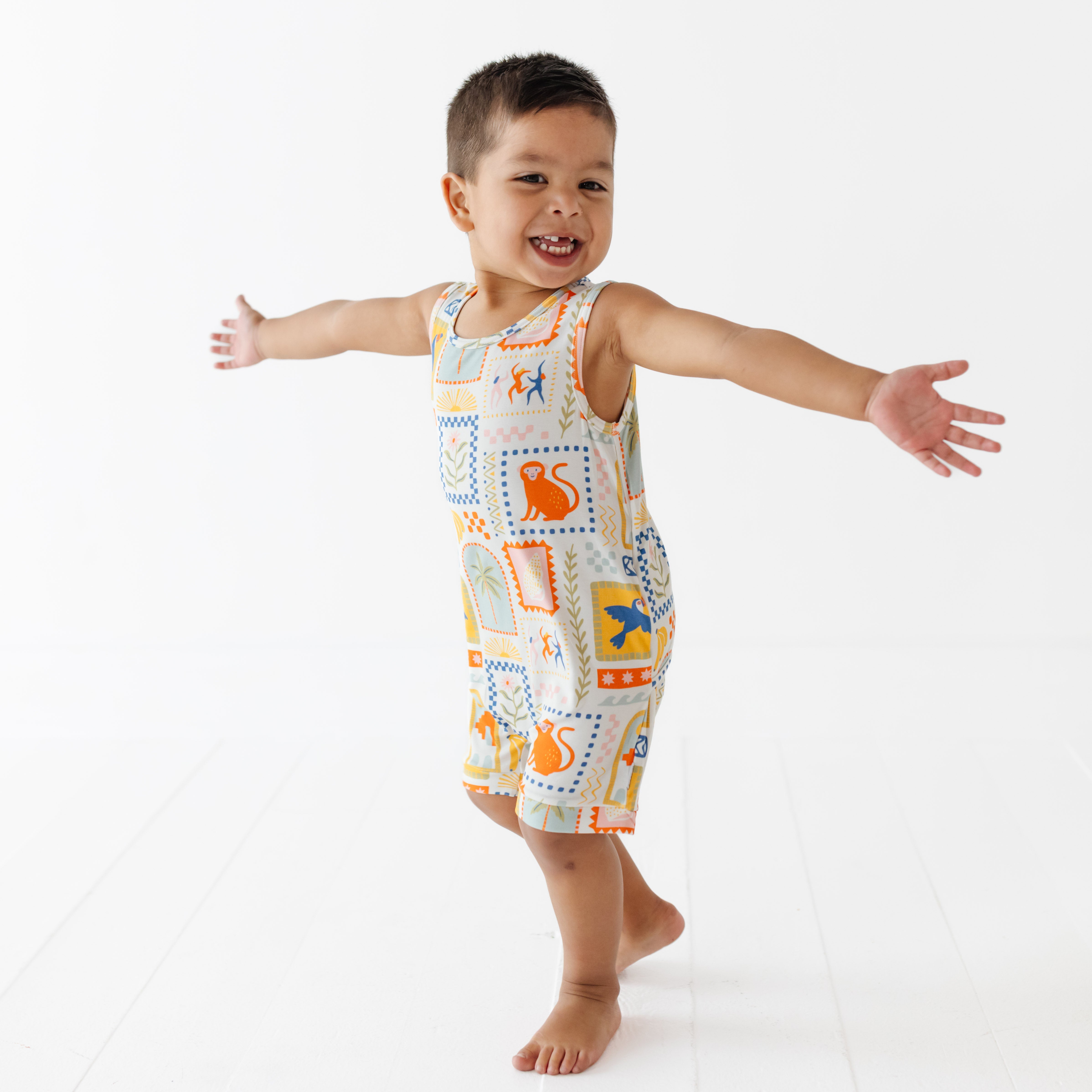 Child wearing a colorful patterned romper on a white background