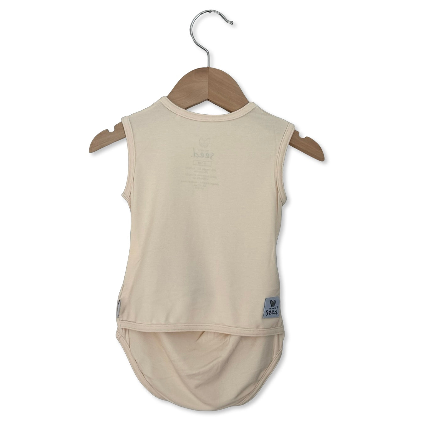 Beige sleeveless top on a wooden hanger against a white background