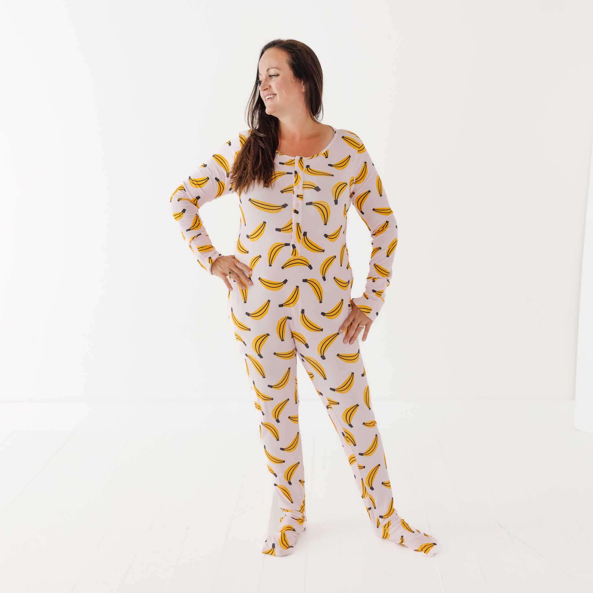 Woman wearing a banana-patterned onesie on a white background
