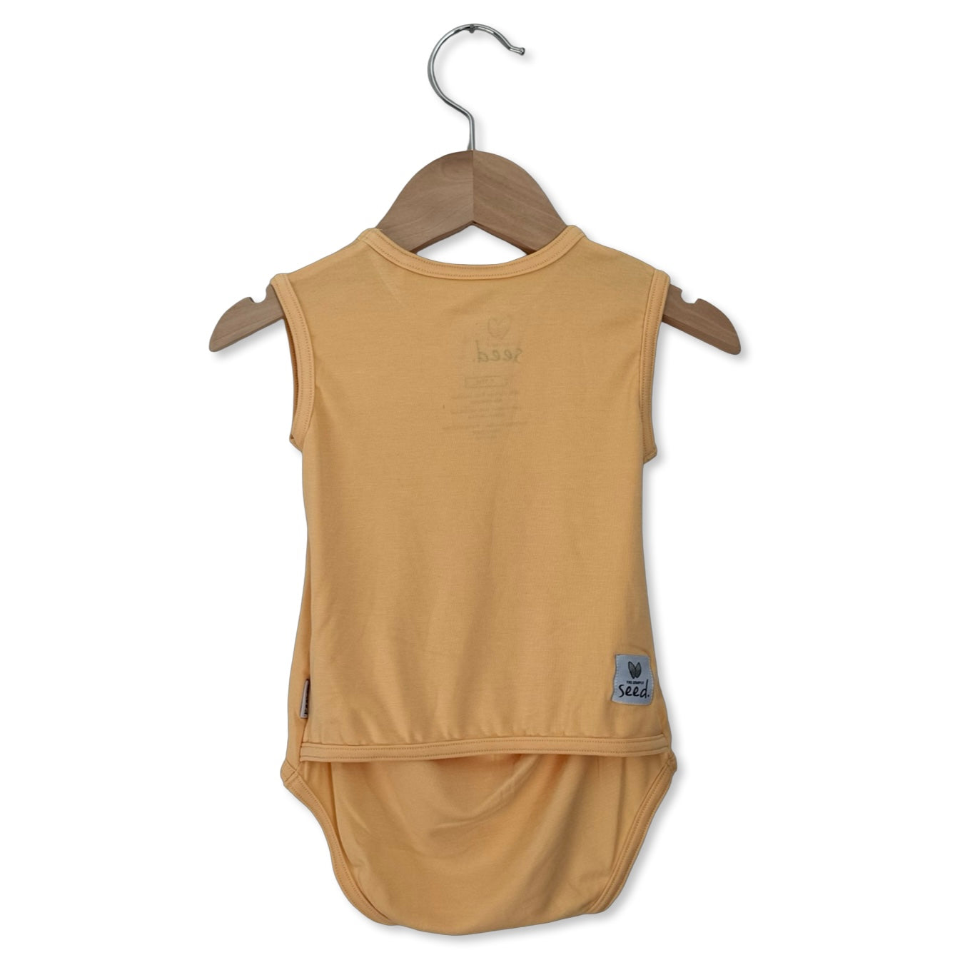 Beige sleeveless baby outfit on a hanger against a white background