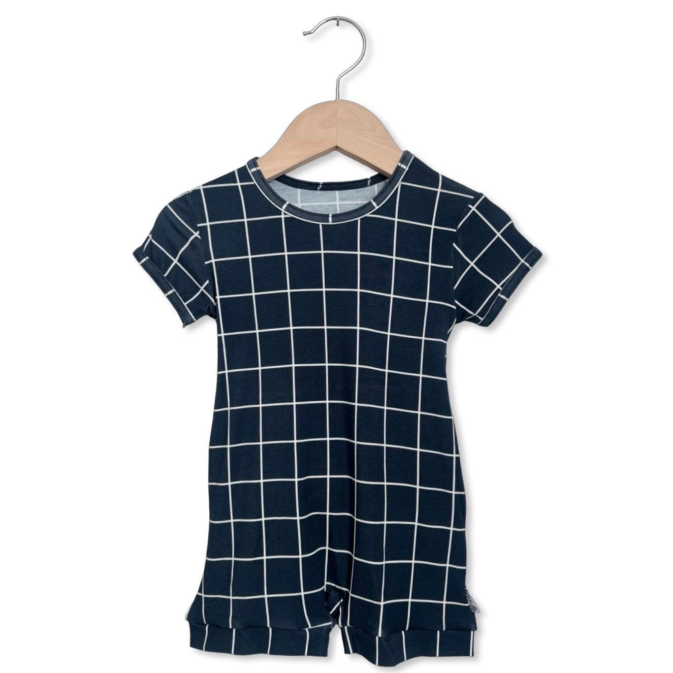 Navy grid-patterned romper on a wooden hanger against a white background