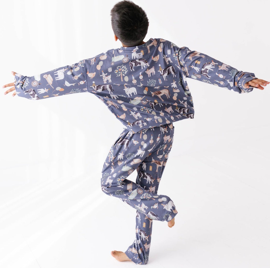 Person wearing a blue pajama set with animal pattern on a white background