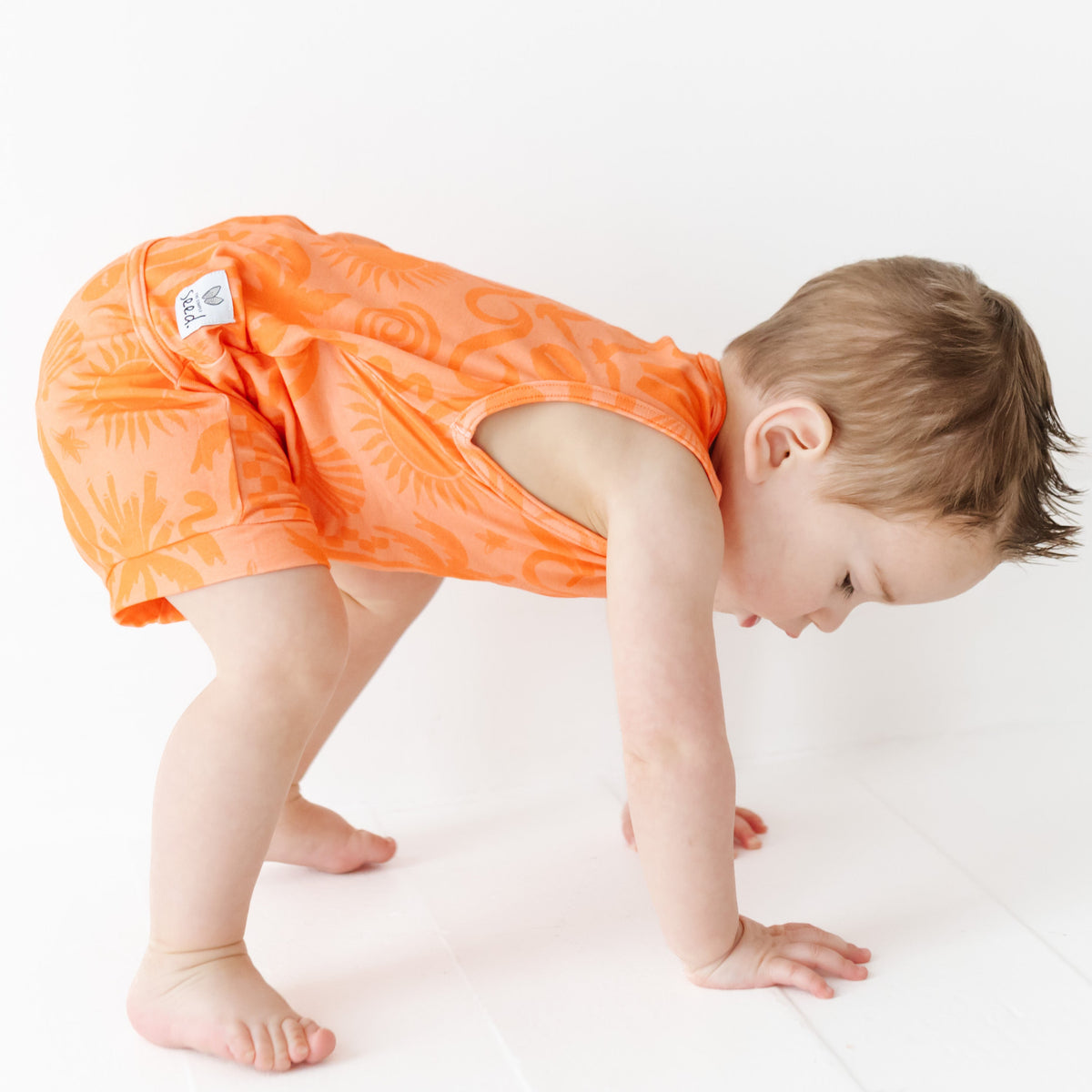 Child wearing an orange diaper on a white background