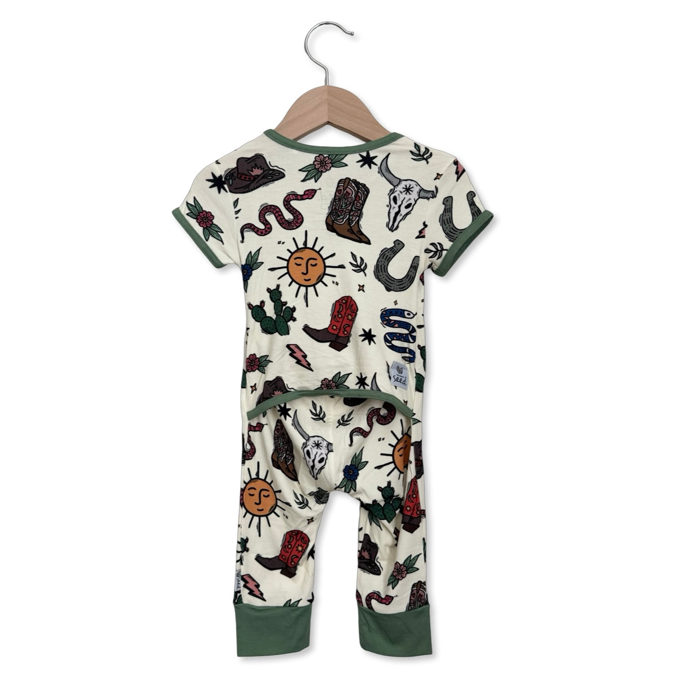 Children's onesie with cowboy-themed design on a hanger against a white background