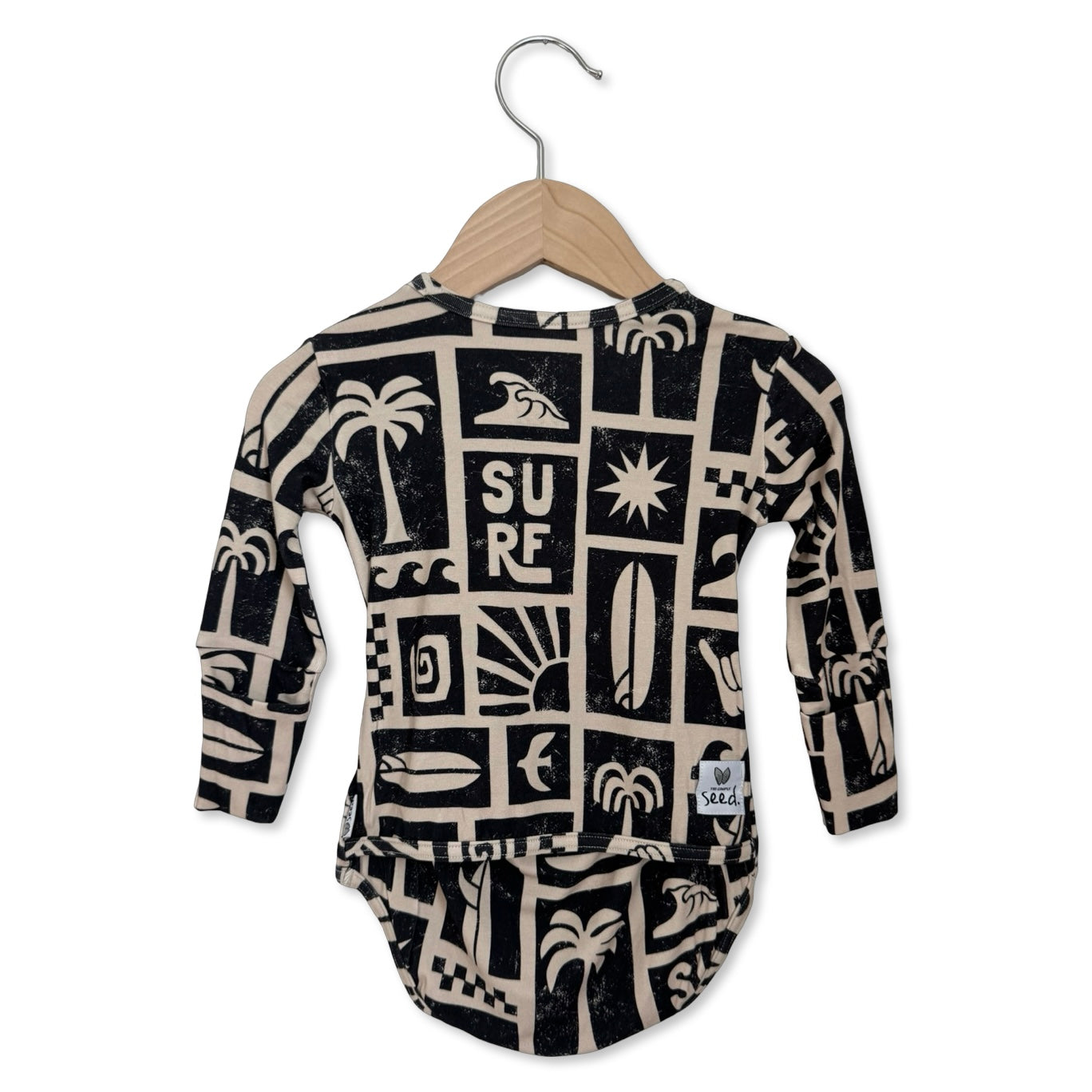 Baby onesie with surf-themed pattern on a hanger against a white background