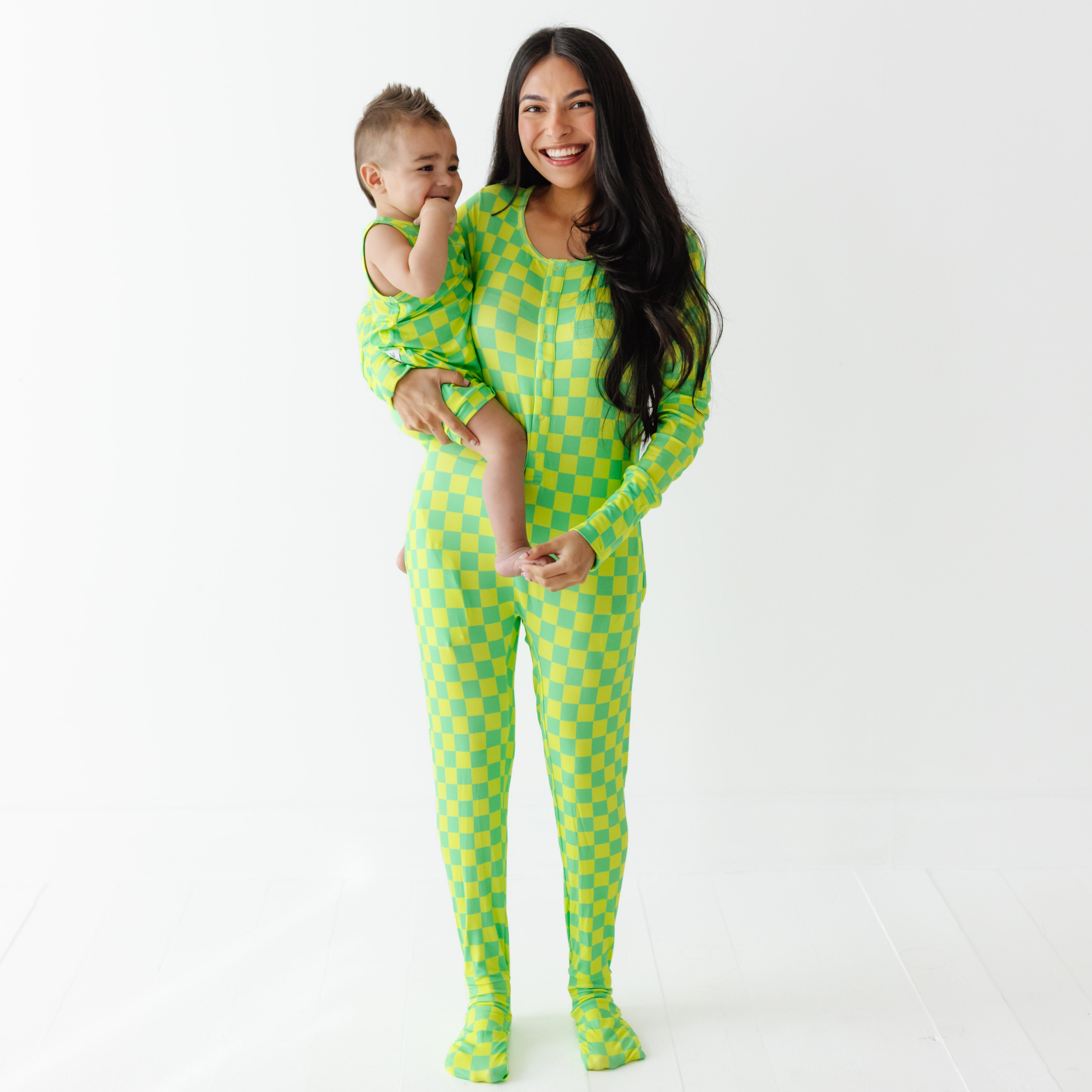 Woman and child wearing matching green checkered outfits on a white background