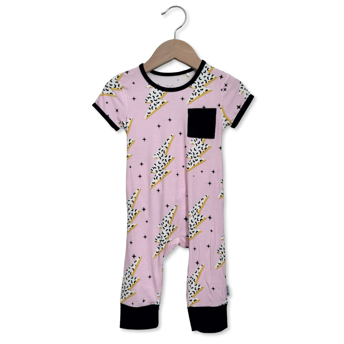 Pink baby onesie with black and gold patterns on a hanger against a white background