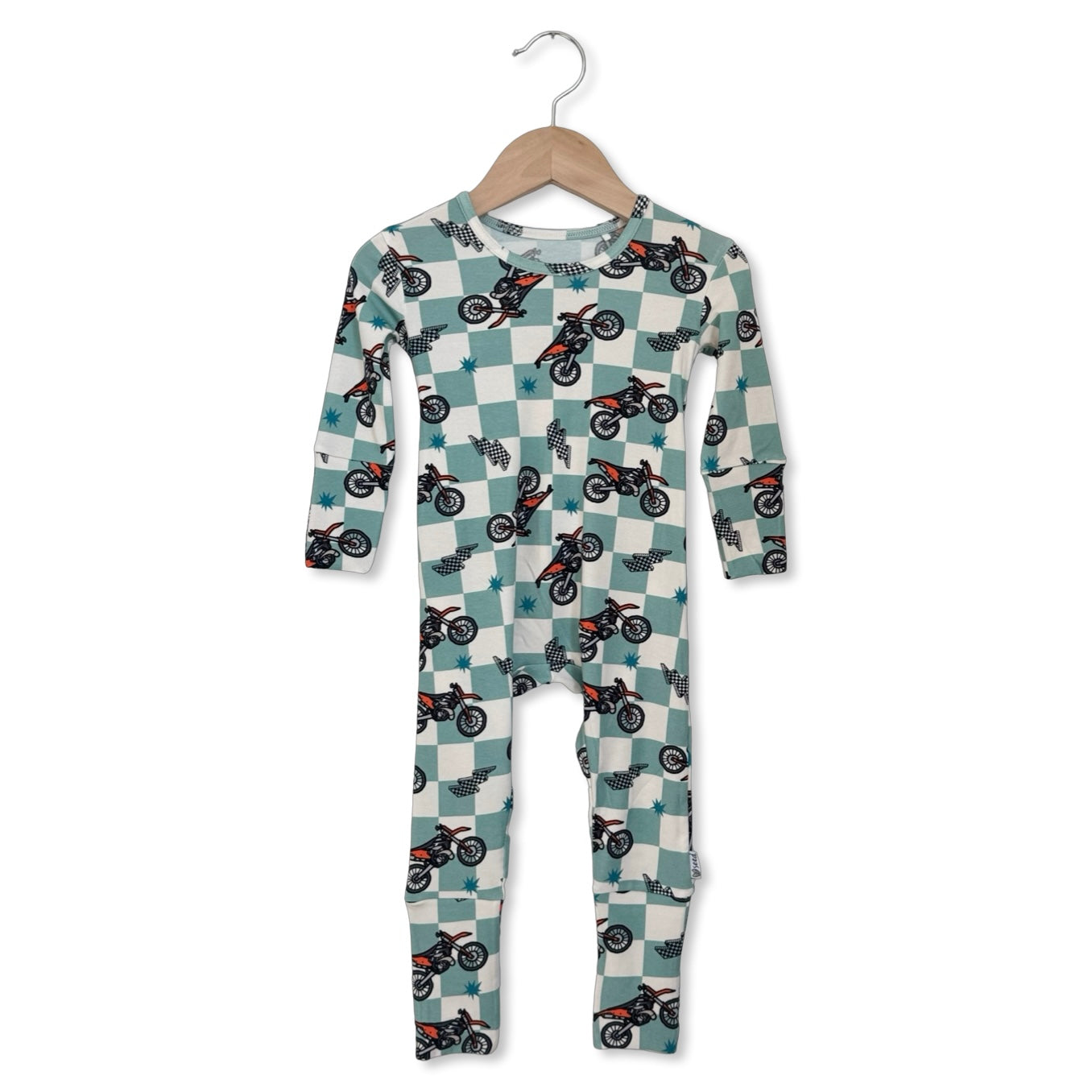 Children's onesie with motorcycle pattern on a hanger against a white background