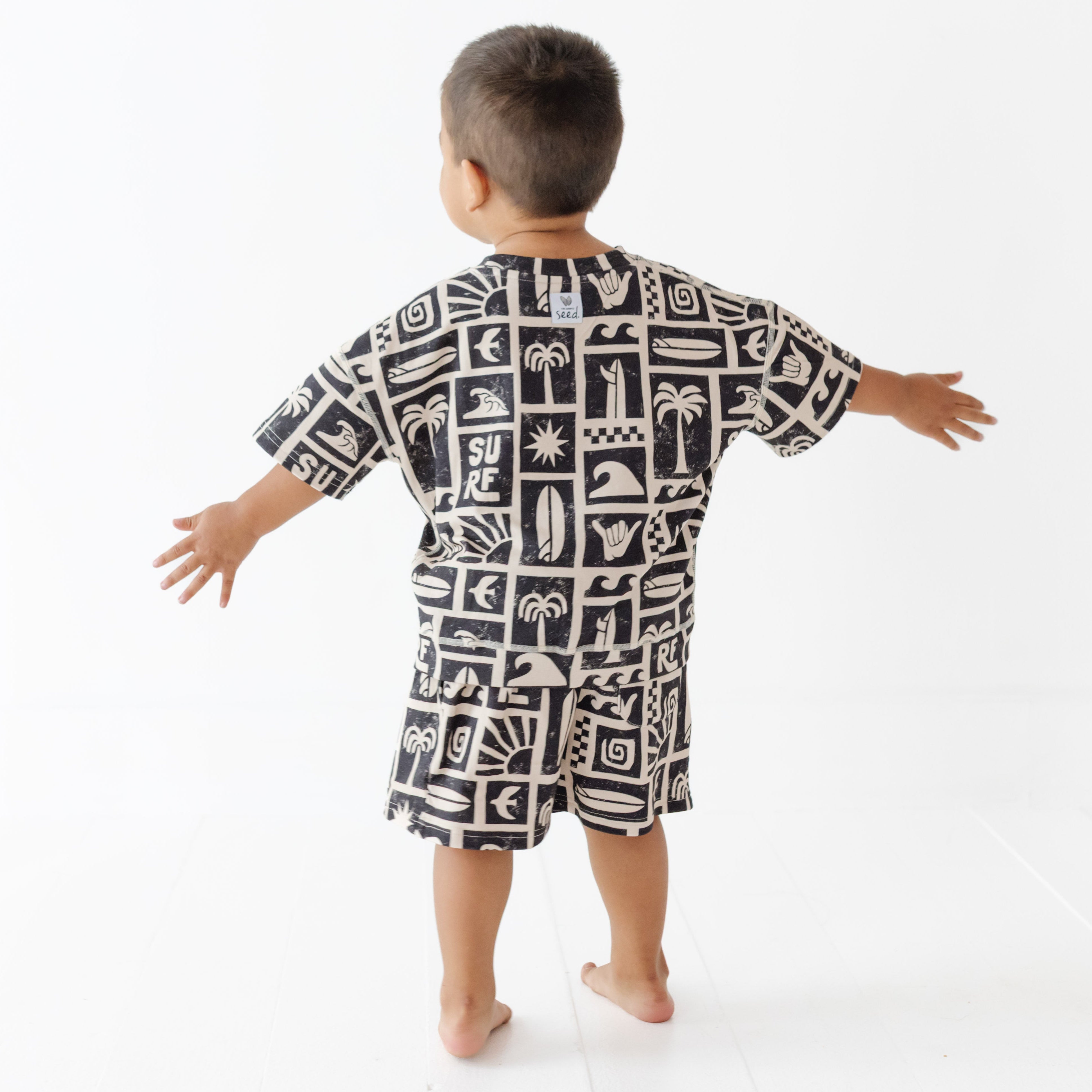 Child wearing a black and white patterned shirt on a white background