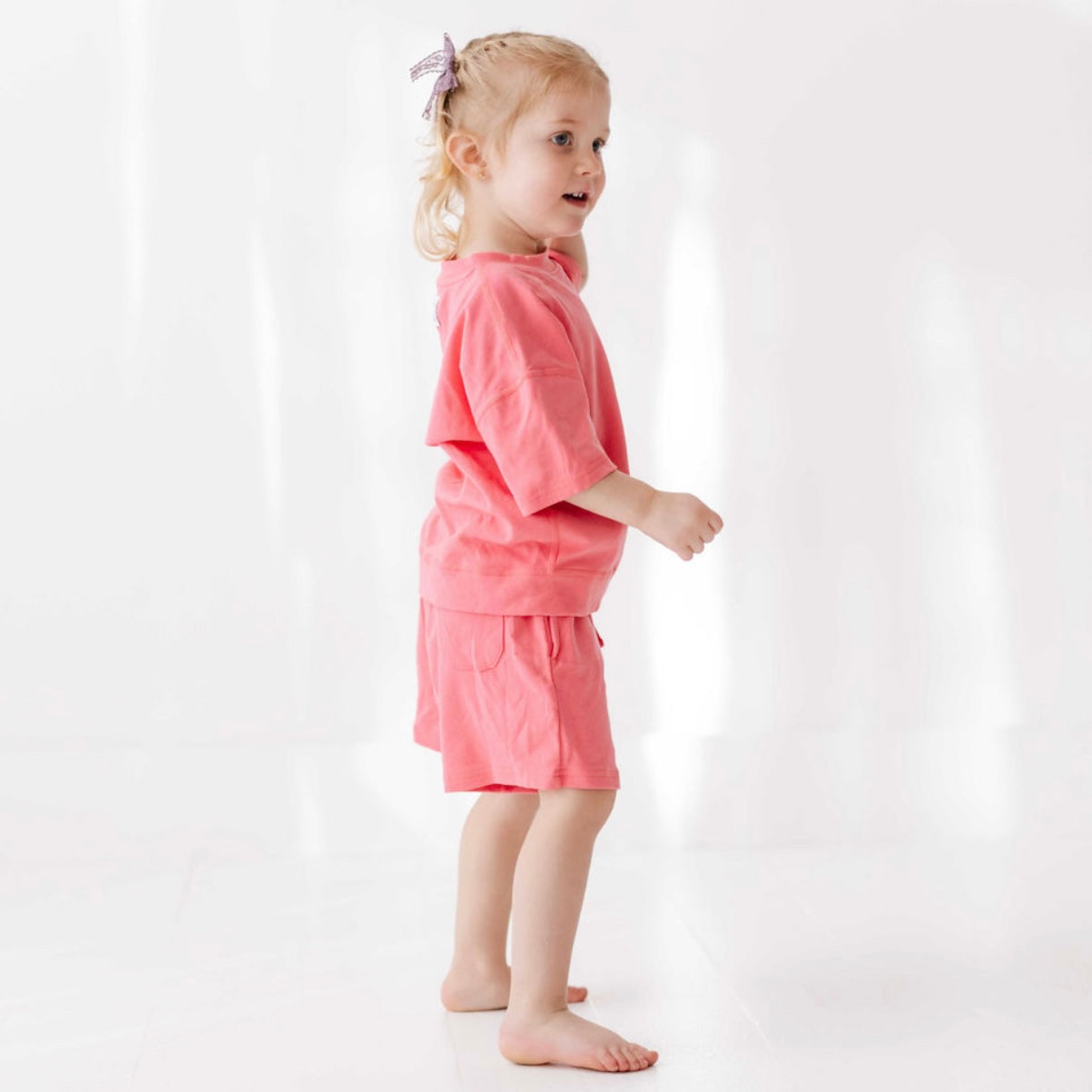 Young girl wearing a pink outfit on a white background
