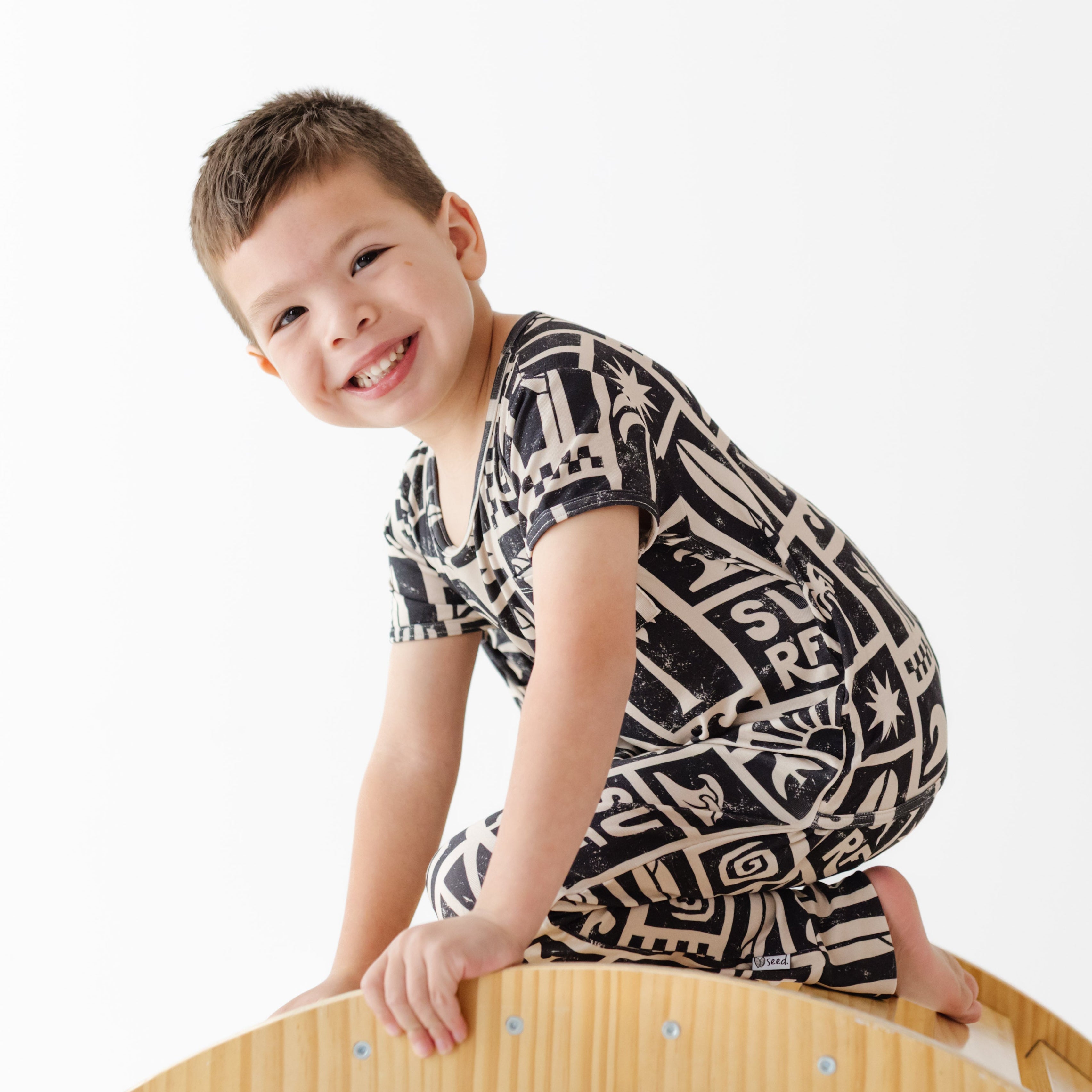Child wearing a black and white patterned shirt on a white background