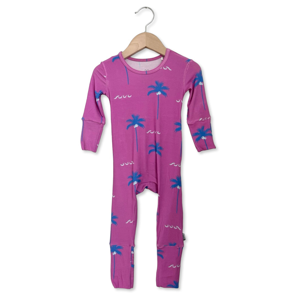 Purple baby onesie with palm tree pattern on a hanger against a white background
