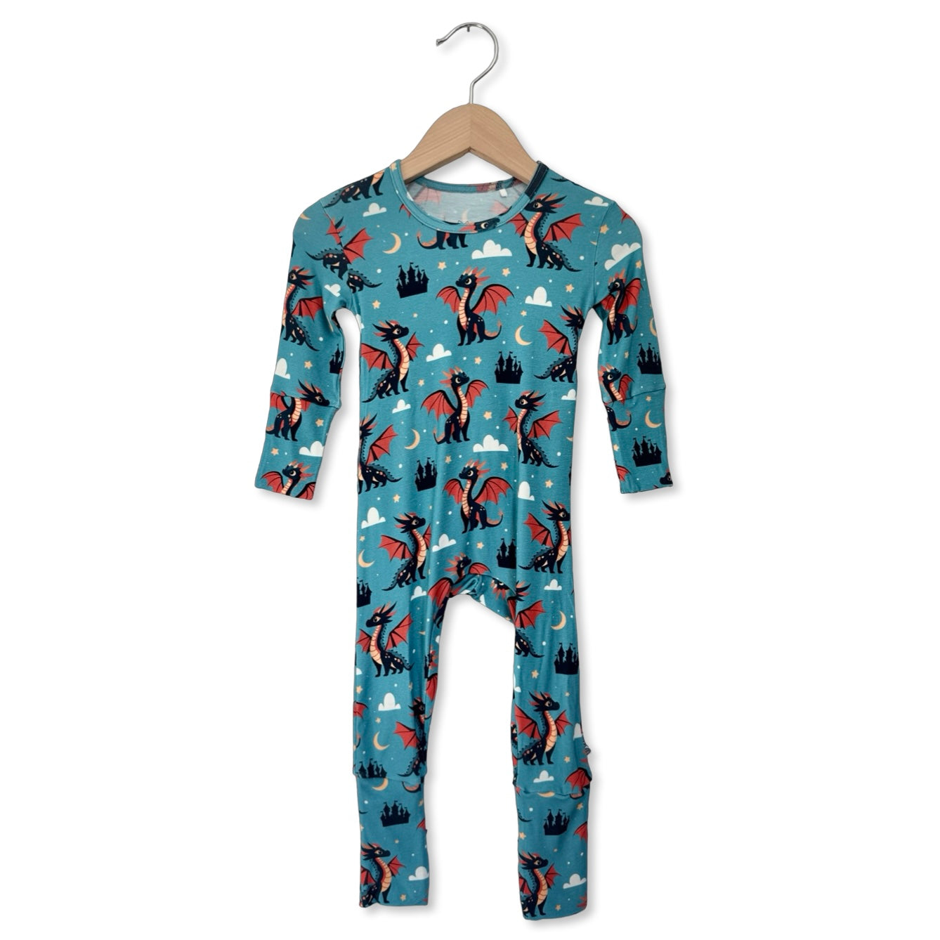 Children's onesie with dragon pattern on a hanger against a white background