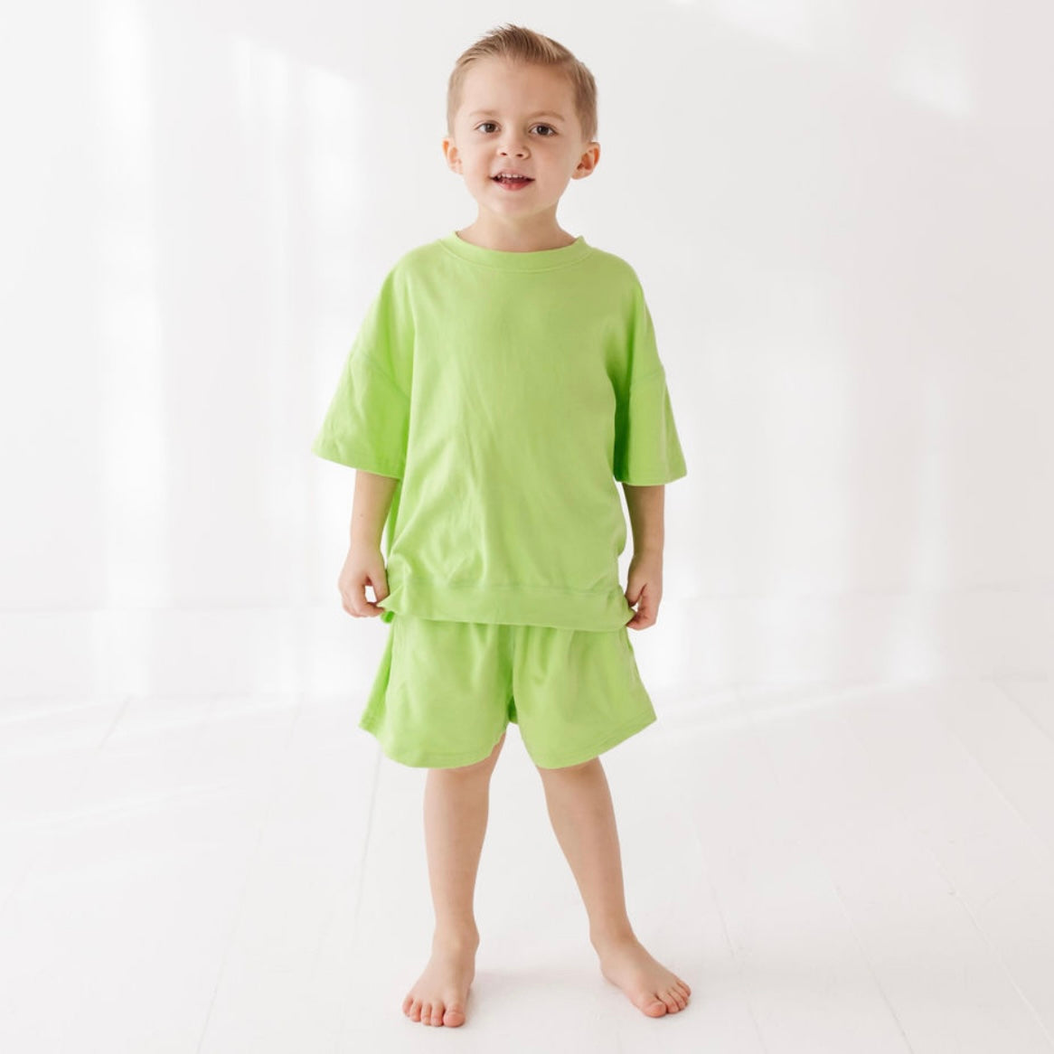 Child wearing a green outfit on a white background