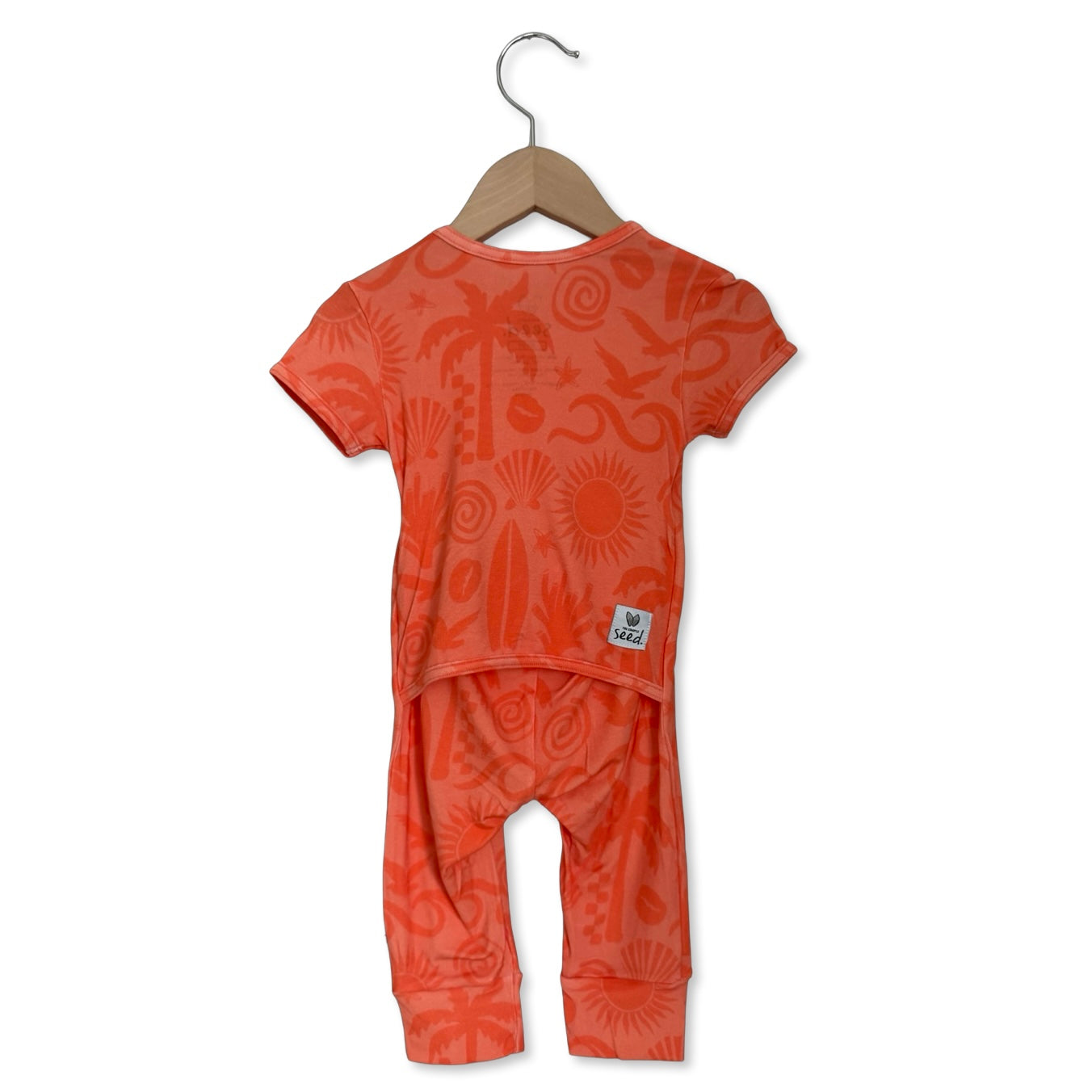Orange children's outfit with patterns on a hanger against a white background