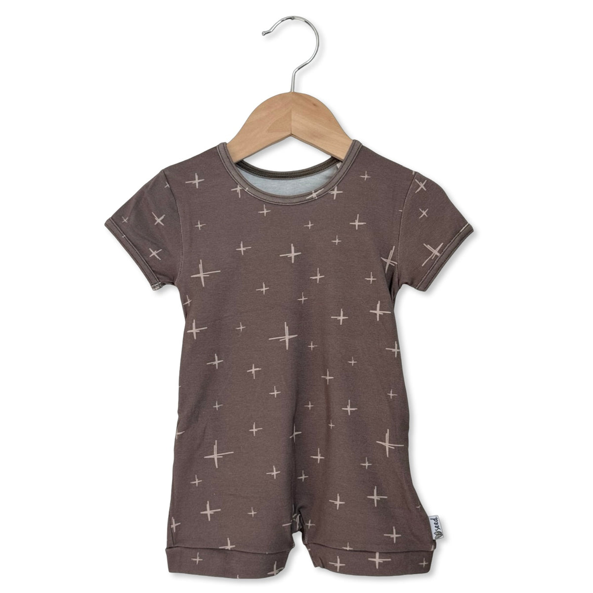 Children's brown romper with star pattern on a hanger against a white background