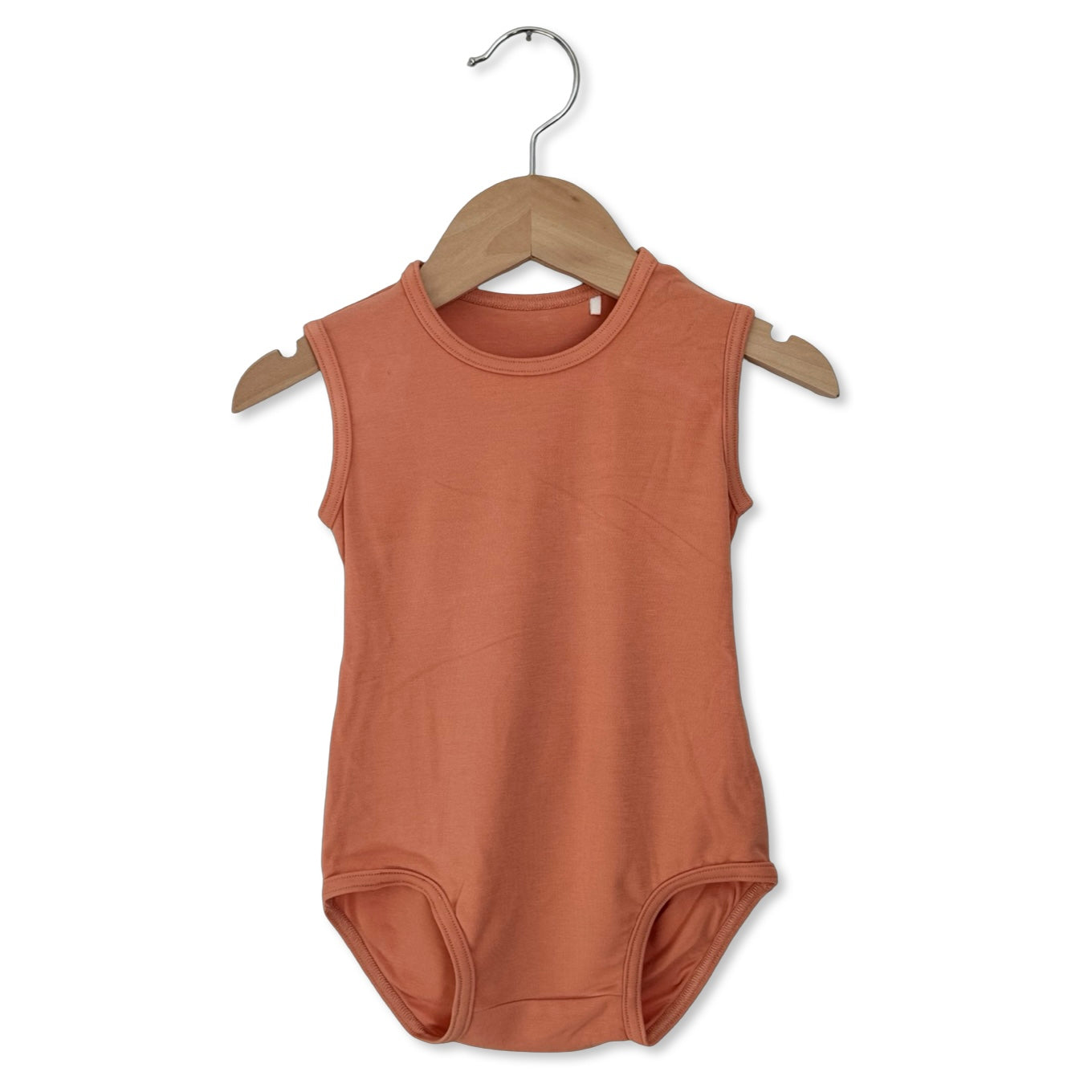Brown sleeveless bodysuit on a wooden hanger against a white background