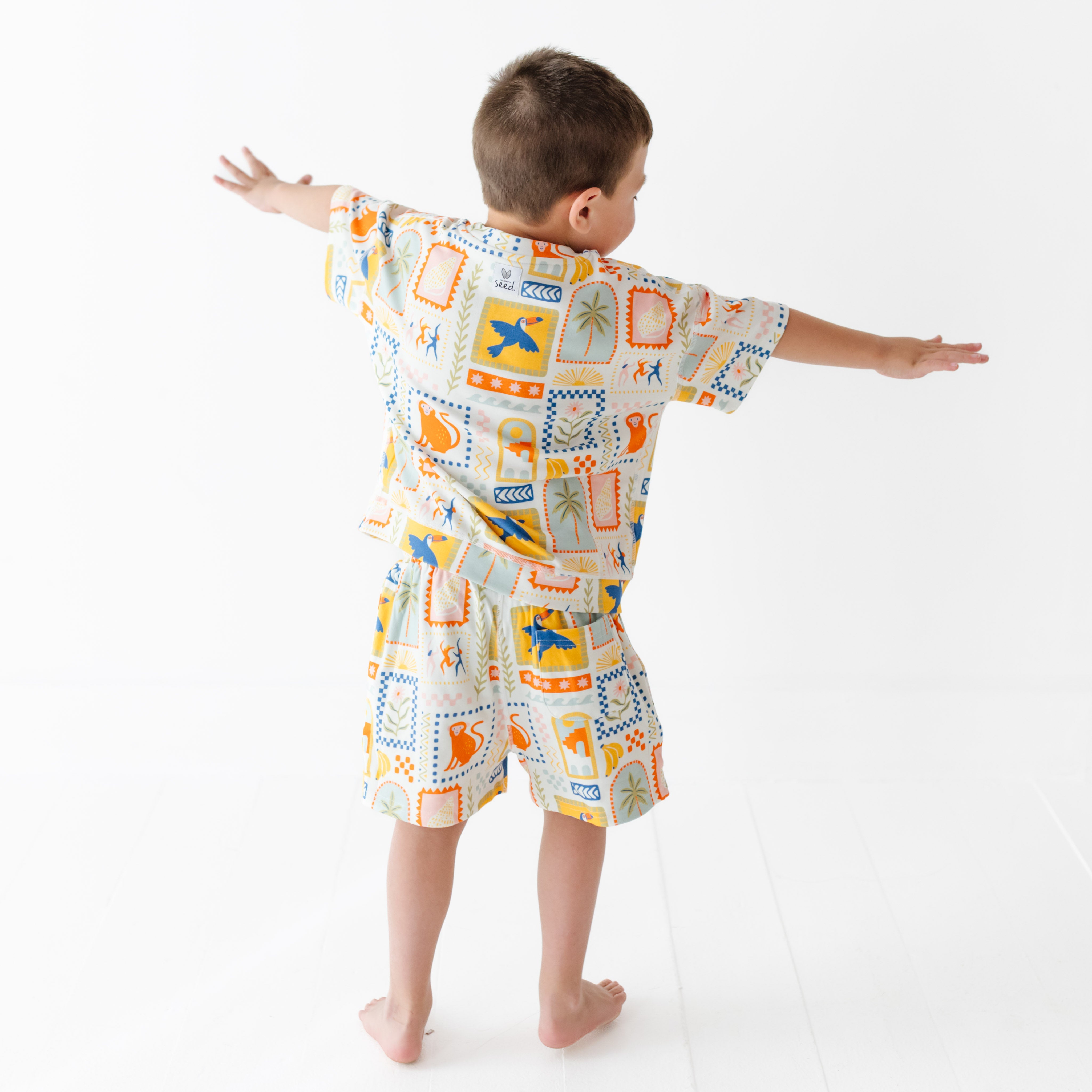 Child wearing a colorful patterned outfit on a white background