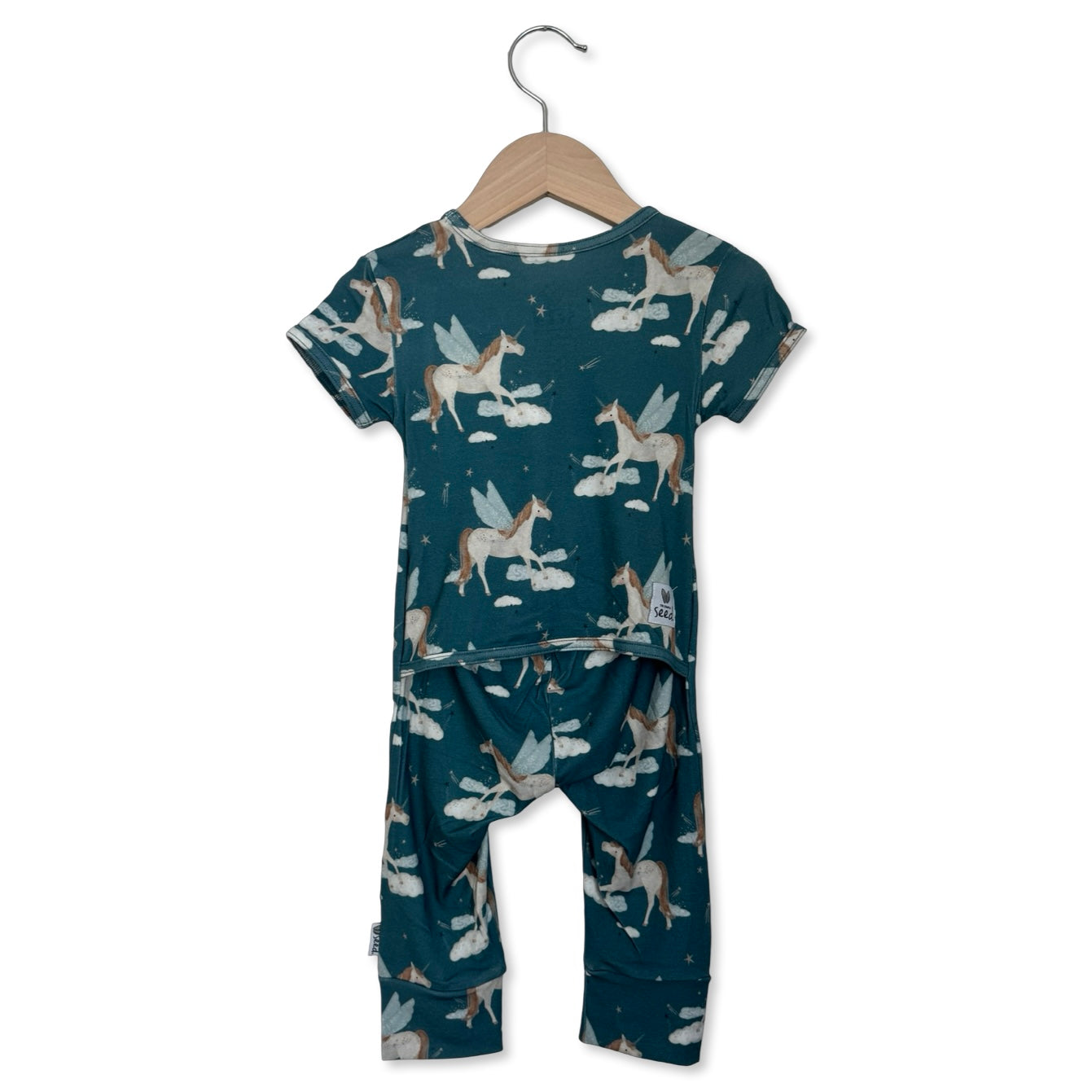 Children's pajama set with unicorn pattern on a hanger against a white background
