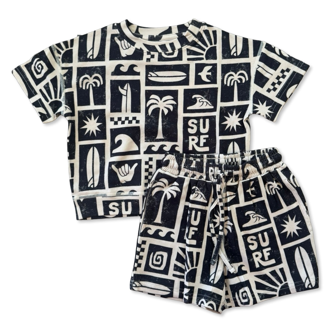 Children's t-shirt and shorts set with black and white surf-themed pattern on a white background