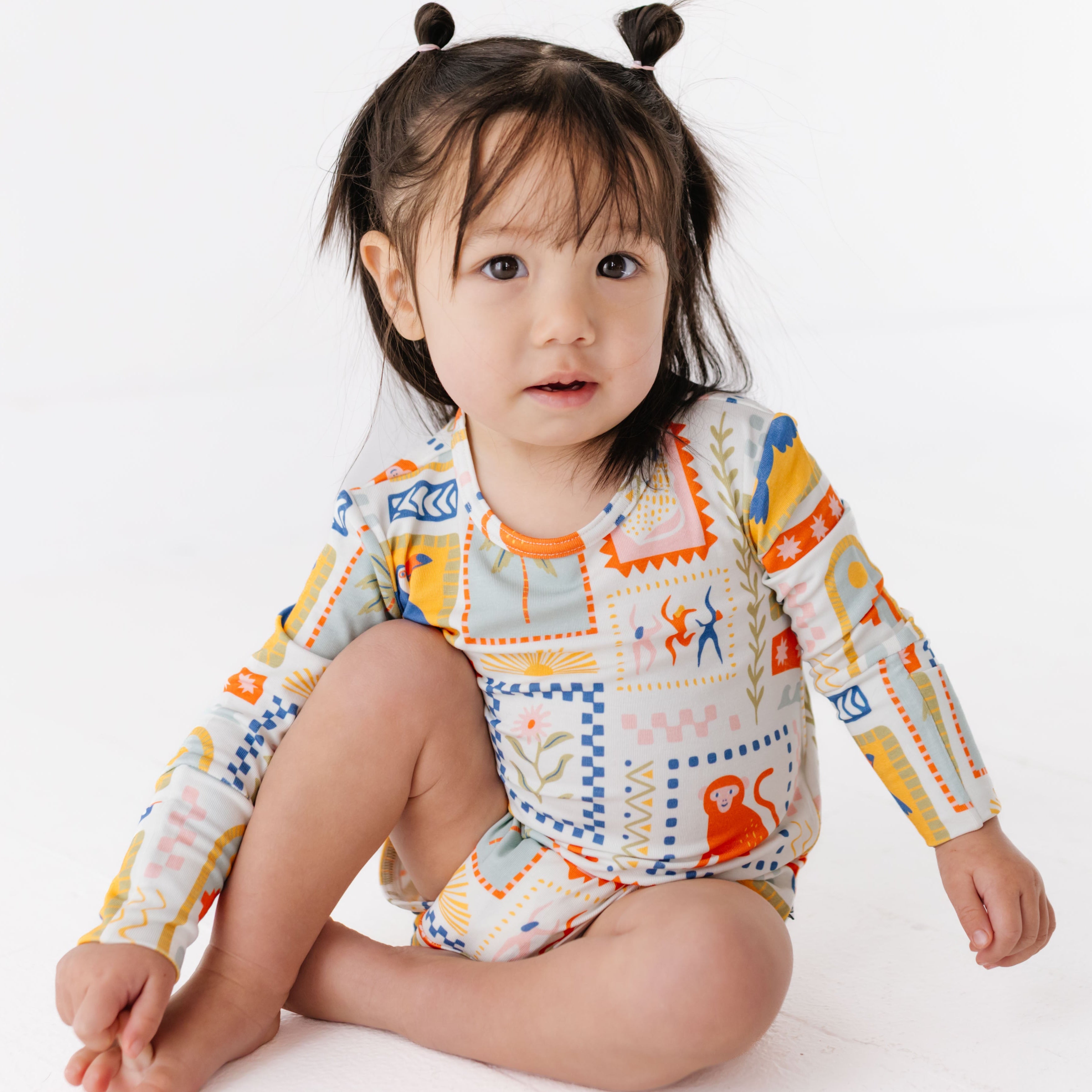Child wearing a colorful outfit with patterns on a white background
