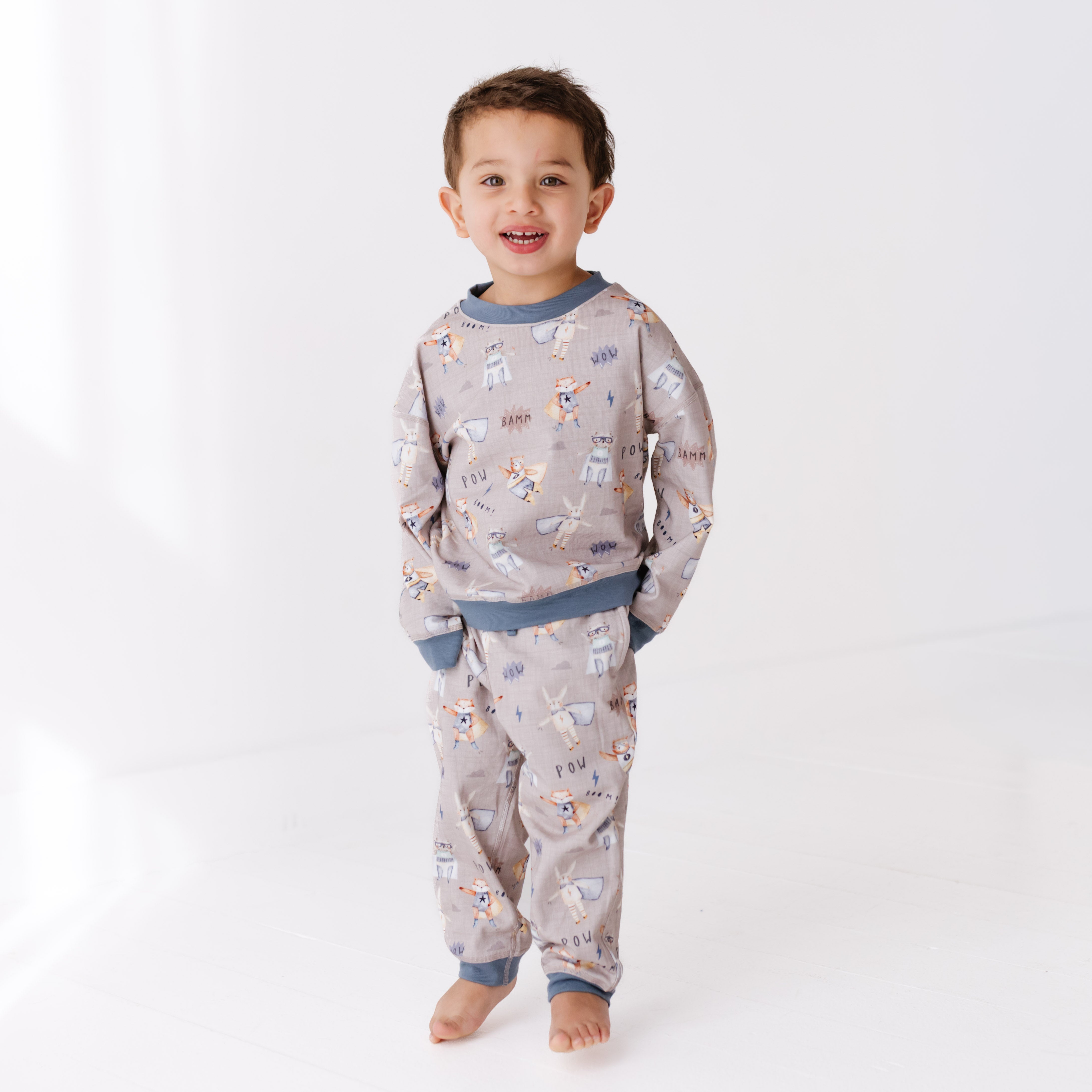 Child wearing a patterned sweat set on a white background