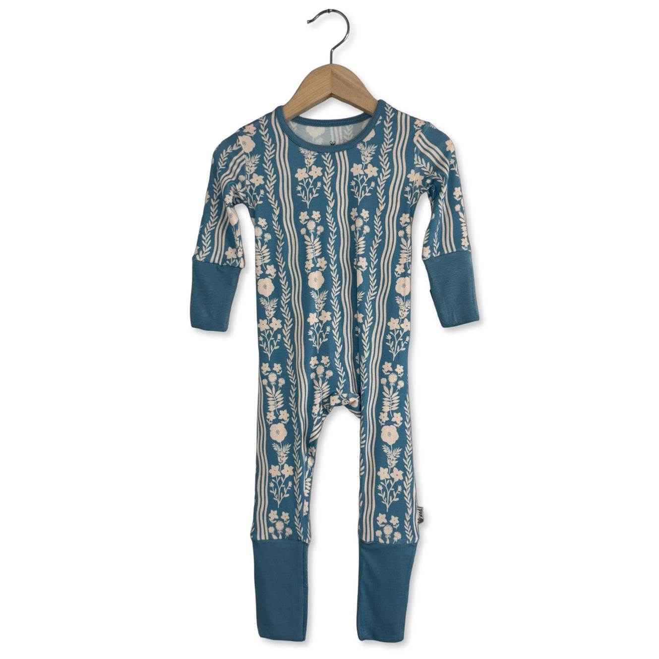 A blue long-sleeved romper with a floral pattern, displayed on a hanger.