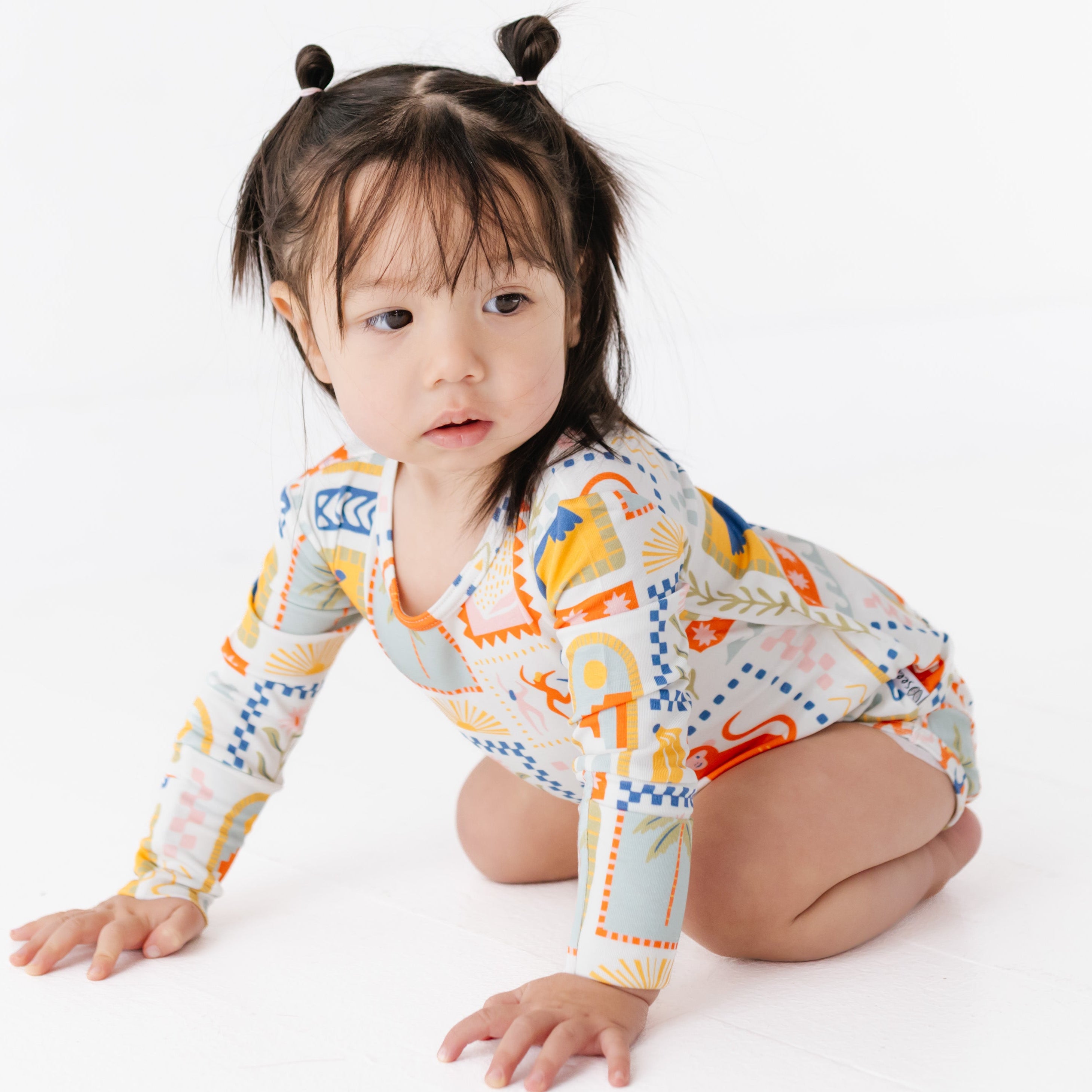 Child wearing a colorful long-sleeve shirt on a white background