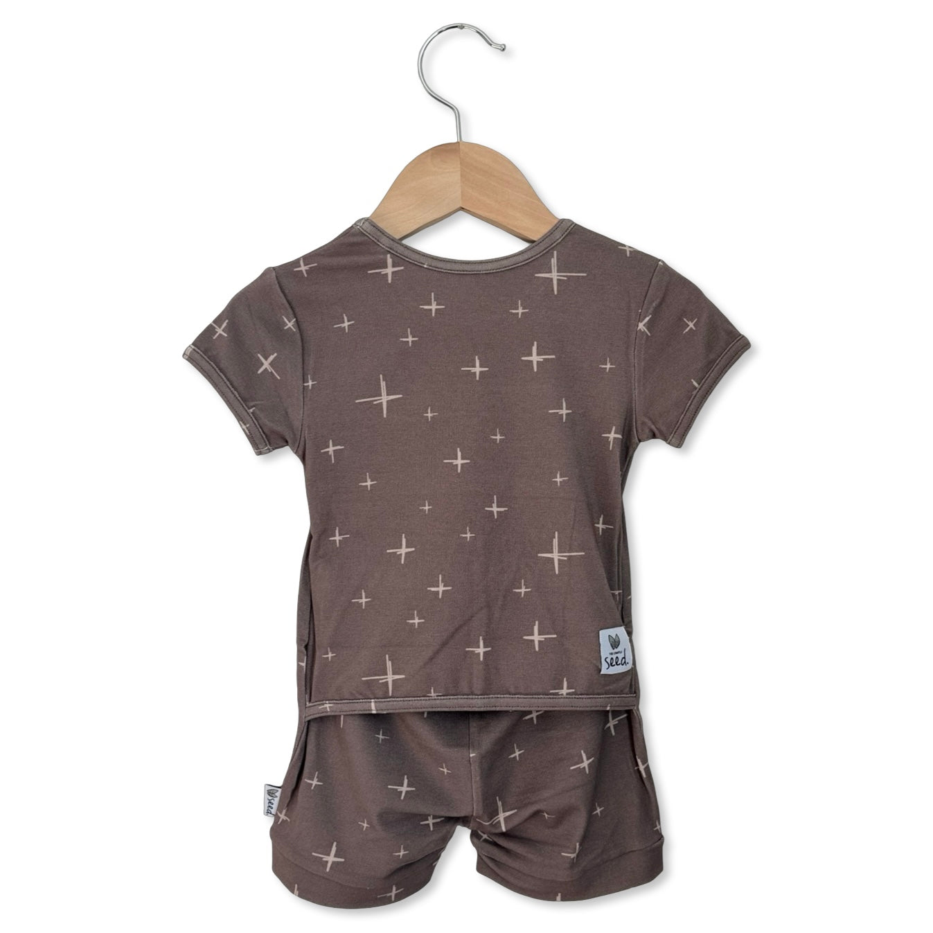 Children's pajama set with star pattern on a hanger against a white background