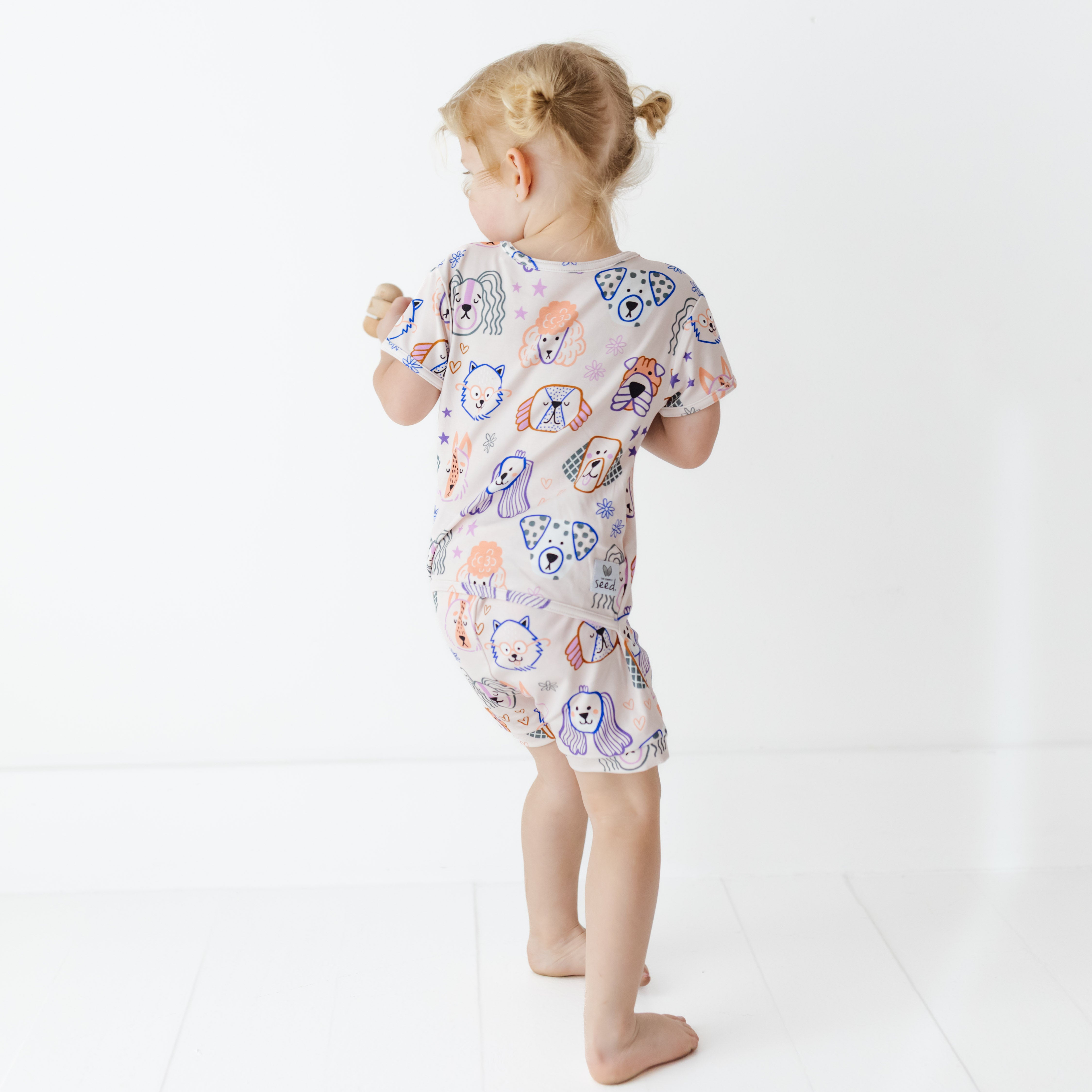 Child wearing a patterned dog outfit on a white background