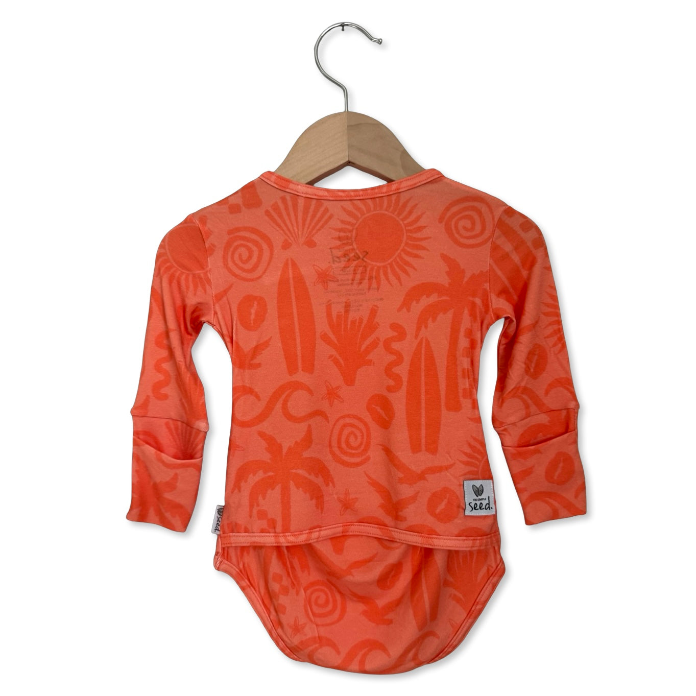 Orange baby outfit with patterns on a hanger against a white background