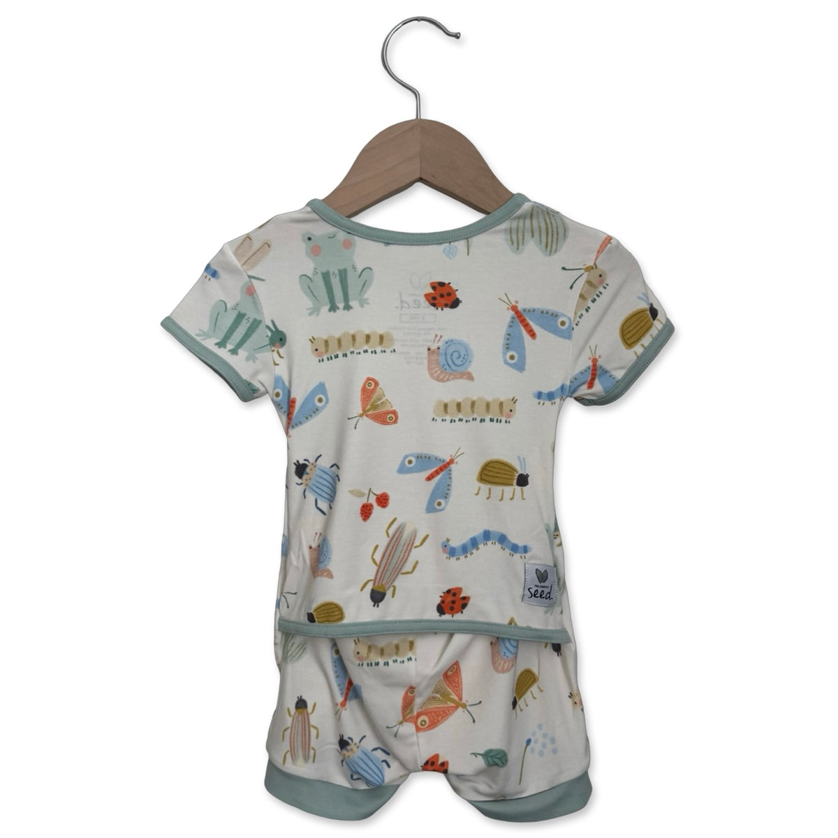 Baby romper with animal pattern on a hanger against a white background