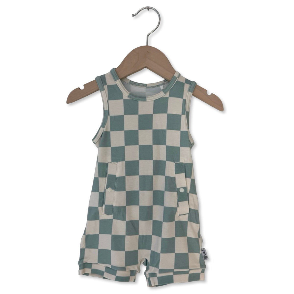 Checkered romper on a wooden hanger against a white background