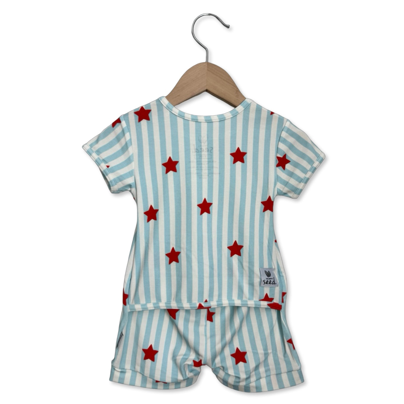 Children's outfit with red star pattern on a hanger against a white background