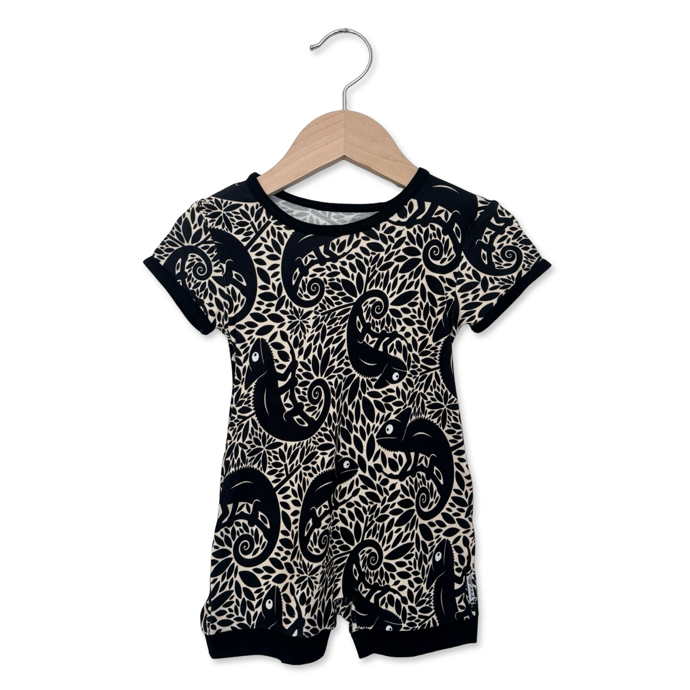 Black and white patterned baby romper on a hanger against a white background