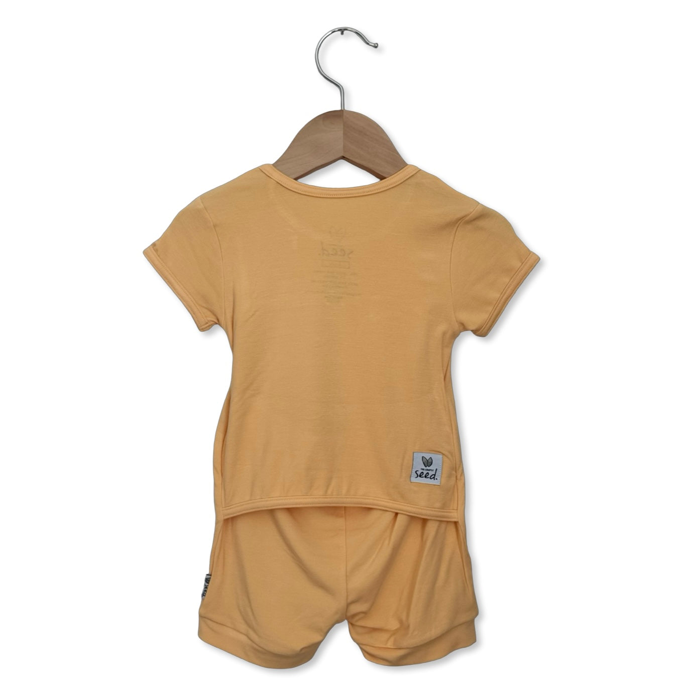 Beige t-shirt and shorts set on a hanger against a white background