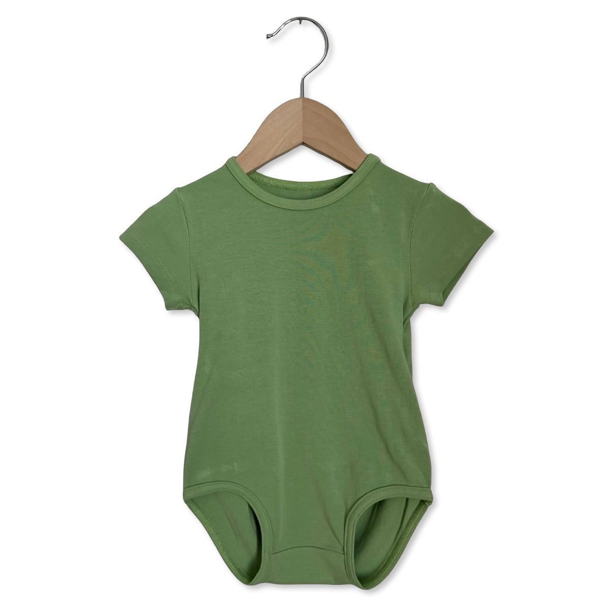 Green baby bodysuit on a wooden hanger against a white background