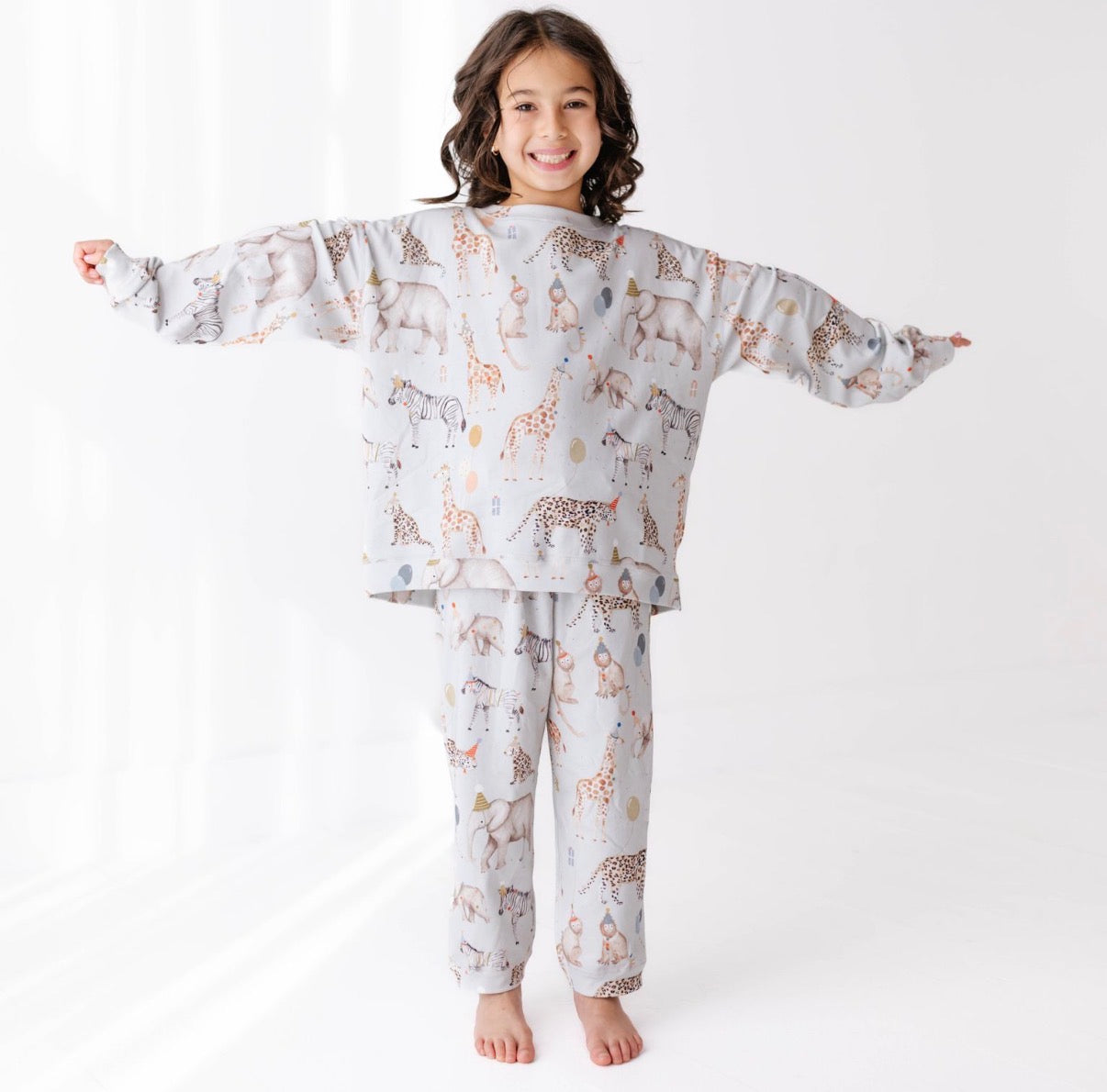 Child wearing a sweat set with animal pattern on a white background