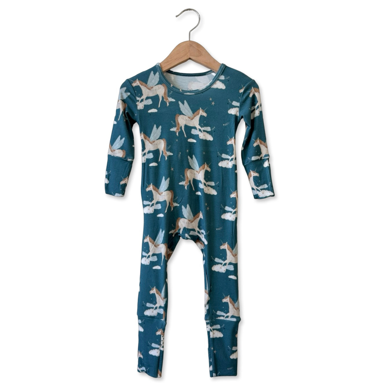 Children's onesie with horse pattern on a hanger against a white background