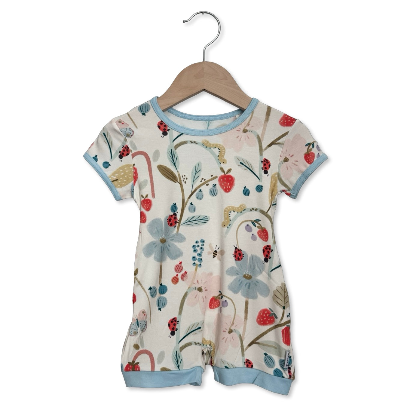 Children's floral romper on a hanger against a white background