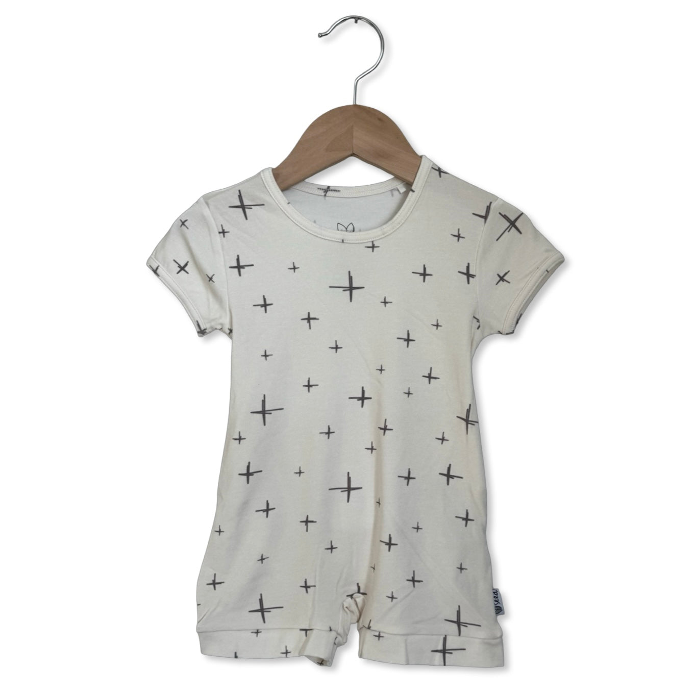 Baby romper with star pattern on a hanger against a white background