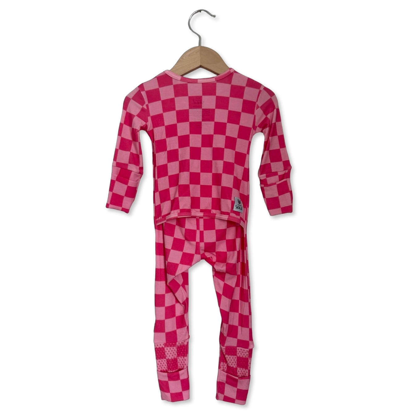 Pink checkered pajama set on a hanger against a white background