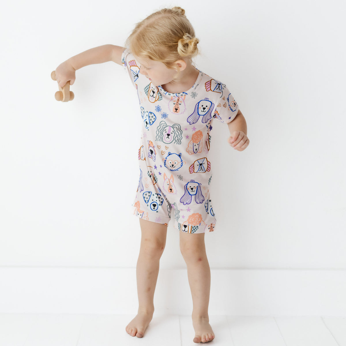 Child wearing a patterned onesie on a white background