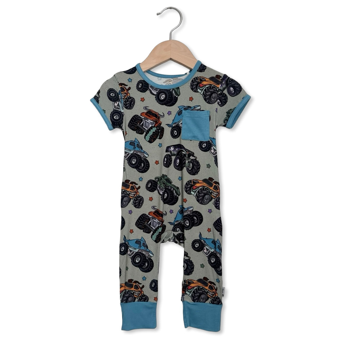 Children's onesie with monster truck pattern on a hanger against a white background