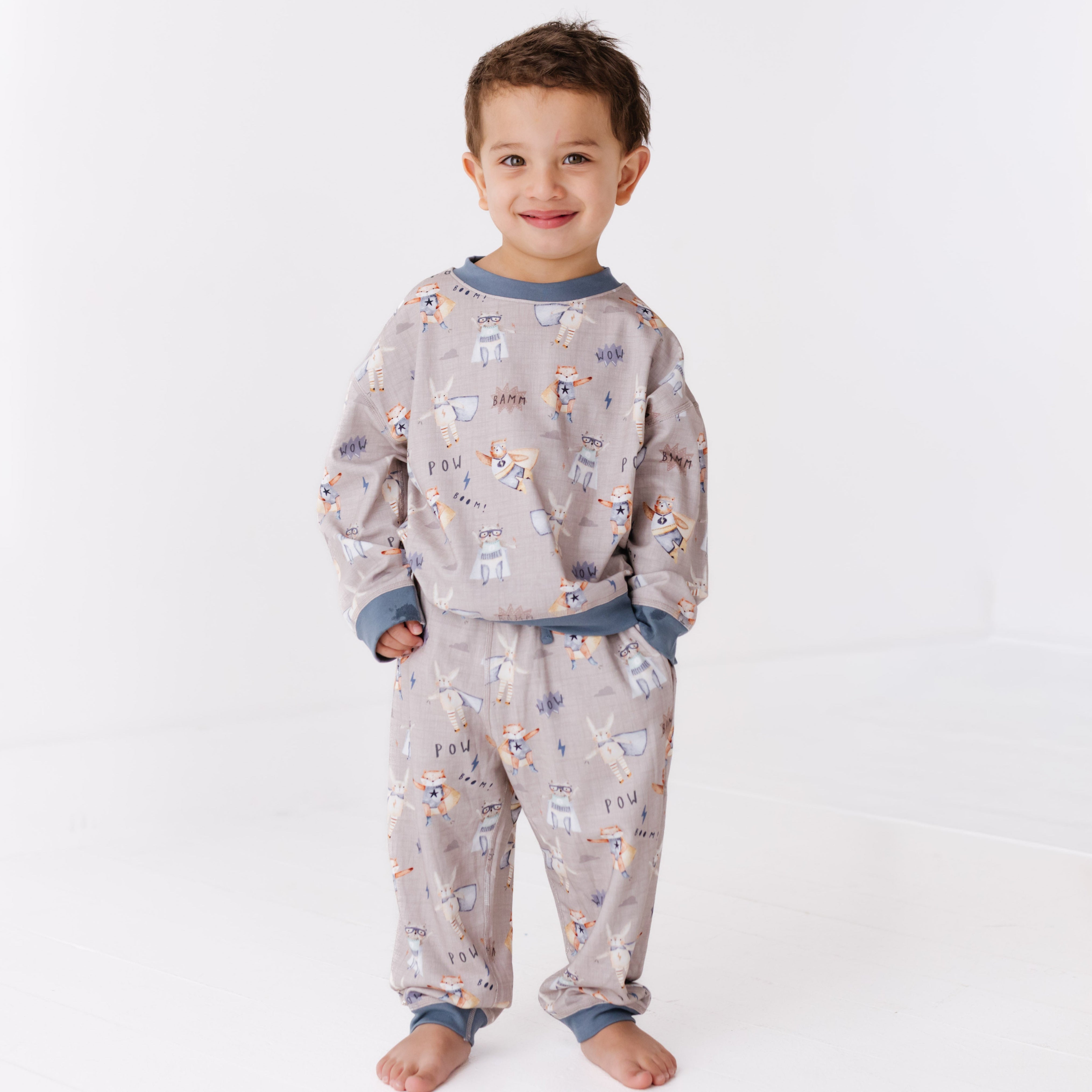 Child wearing a patterned sweat set on a white background