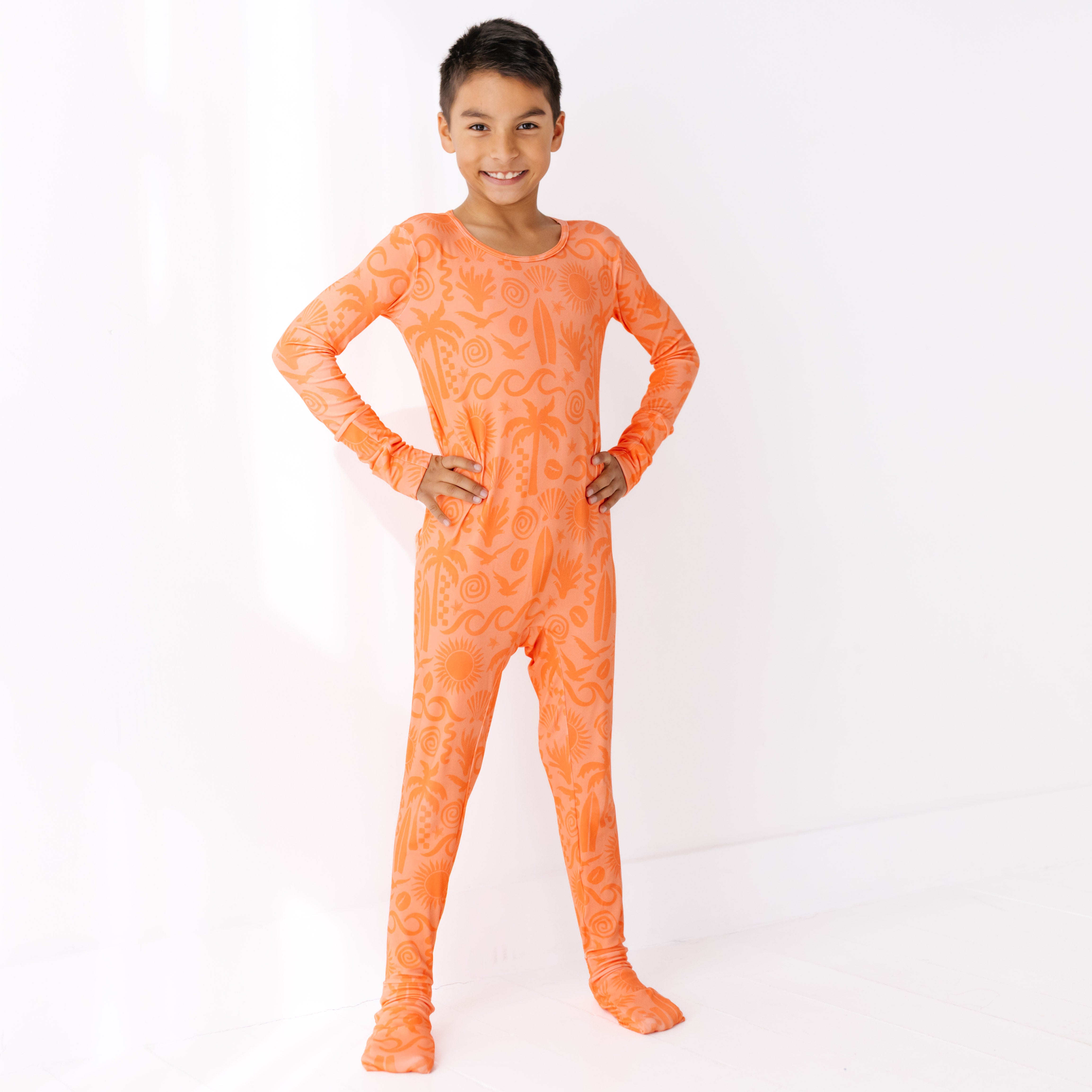 Child wearing an orange tie-dye onesie on a white background