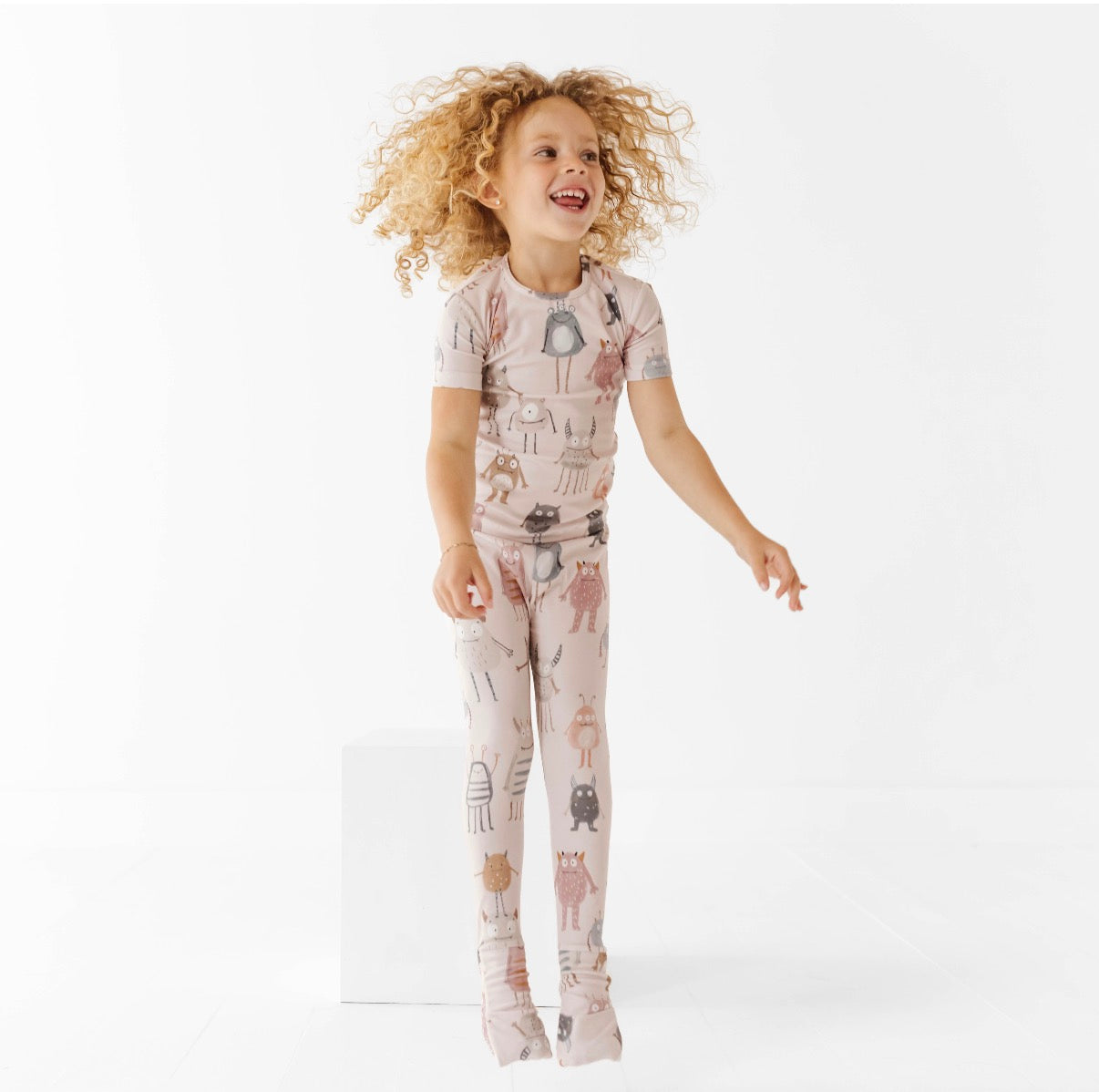 Child wearing a patterned outfit on a white background