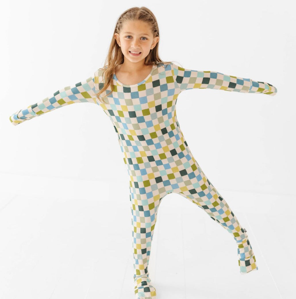 Child wearing a colorful checkered onesie on a white background